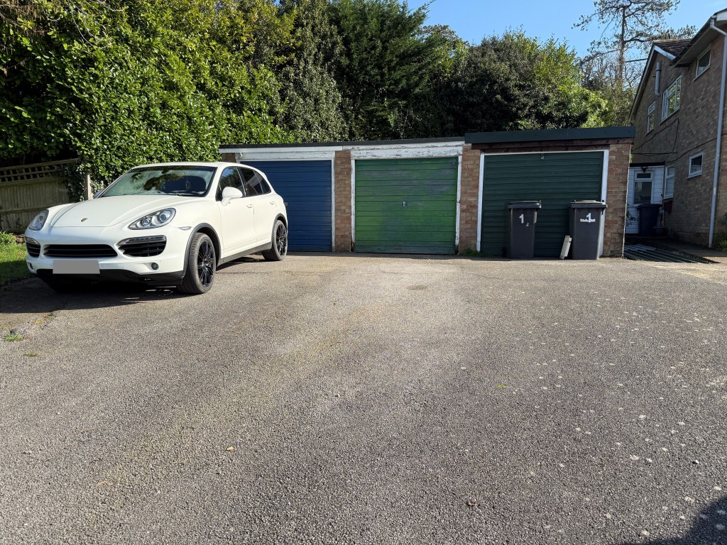 Lot: 134 - TWO-BEDROOM FLAT WITH GARAGE IN NEED OF UPDATING - Driveway and garage with green door